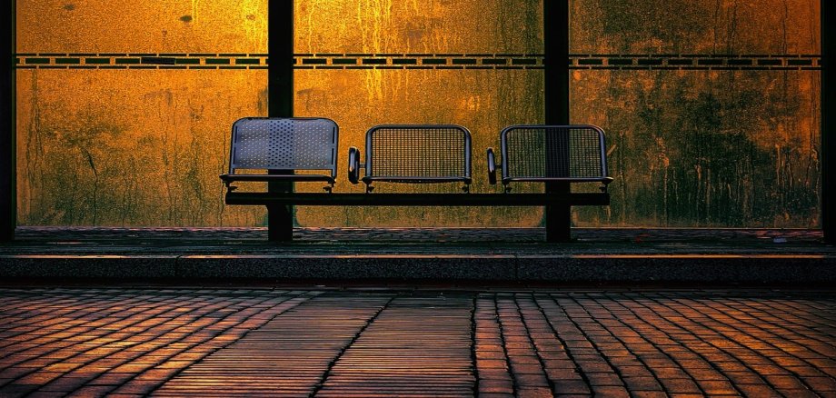 leerer Wartebereich einer Bushaltestelle im Abendlicht